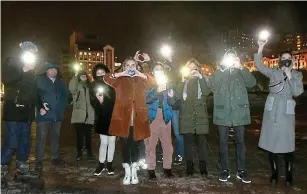  ??  ?? All heart: Supporters use flashlight­s to protest in Vladivosto­k and (right) Alexei Navalny makes heart shape in court