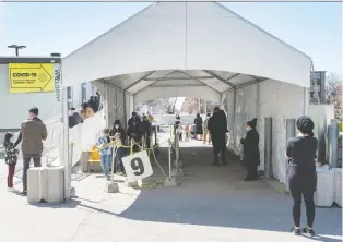  ?? RYAN REMIORZ/ THE CANADIAN PRESS ?? People line up at a COVID-19 testing clinic in Montreal on Tuesday. Premier François Legault has urged Quebecers to take as many precaution­s as possible to stop the spread of COVID-19.