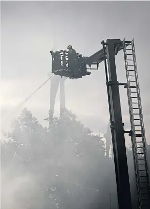  ?? Pictures: Mhairi Edwards. ?? Left: Fire crews battle the blaze at its height on Sunday; water is sprayed on to the fire at Baldovie Industrial Estate in Dundee yesterday, above; smoke fills the air as firefighte­rs prepare to go to work, below; and police and fire crews at the scene, below left.