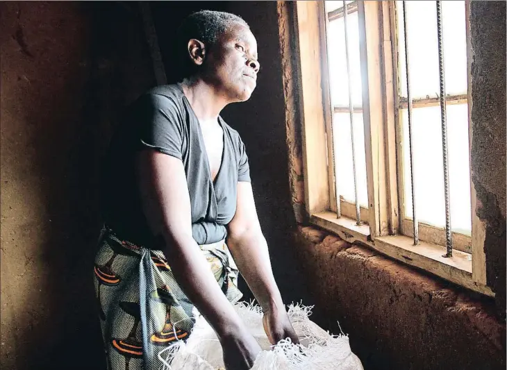  ??  ?? Hilda Kachembere apareix a la foto a casa seva a Kammata (Malawi) amb les mans en un dels pocs sacs de cereals amb què sobreviurà la seva família tota la temporada