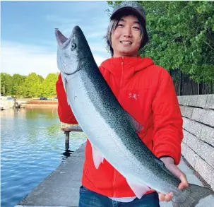  ?? PROVIDED BY QUINN WUNAR ?? Internatio­nal student Jingchen Zhu, who goes by Tony in English, holds his first skamania steelhead. He caught the fish May 30 on the lakefront.