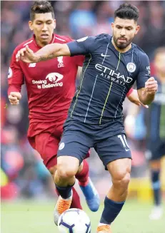  ?? Photo: AFP ?? Manchester City's striker Sergio Aguero (R) vies with Liverpool midfielder Roberto Firmino during the English Premier League match at Anfield in Liverpool, yesterday