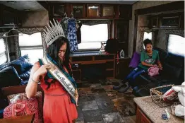  ??  ?? Tracy adjusts her sash in an RV before the start of Texas Gatorfest. The festival marks the opening of alligator-hunting season each year.