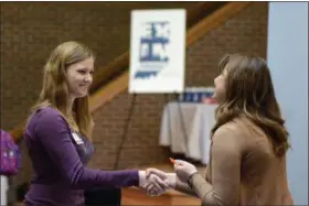  ?? JEFF MOREHEAD — THE CHRONICLE-TRIBUNE VIA AP, FILE ?? Indiana Wesleyan University senior Courtney Kingma, left, thanks Jennie Hehe, community resource manager for Tangram, for talking with her during the Experience Indiana job fair event in the student center at IWU in Marion, Ind.