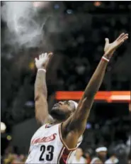  ?? MARK DUNCAN — THE ASSOCIATED PRESS FILE ?? In this file photo, Cleveland Cavaliers’ LeBron James throws talc into the air in a pre-game ritual before an NBA basketball game against the Chicago Bulls in Cleveland.