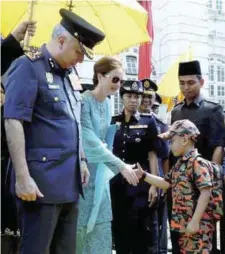  ??  ?? Sultan Nazrin and Raja Permaisuri Perak Tuanku Zara Salim are welcomed by six-year-old Muhammad Irfan Syakir Khairuddin, who was dressed as a fire fighter during the World Fire Fighters Day celebratio­ns in Ipoh yesterday.