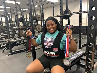  ?? (Staff photo by Mallory Wyatt) ?? Dekalb, Texas, High School sophomore Talisha Ingram holds up the eight medals that she has won from previous powerlifti­ng competitio­ns on Wednesday at Dekalb High School. She won first place at the 2024 Girls State Powerlifti­ng Competitio­n this month .