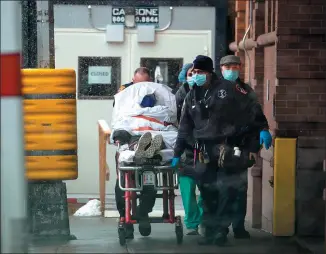  ?? GUO KE / XINHUA ?? Medical workers transfer a COVID-19 patient at a hospital in New York City on Monday as the United States crossed the threshold of 500,000 deaths from COVID-19.