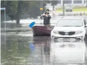  ?? MARK BAKER AP ?? A man paddles down a flooded street on the outskirts of Sydney, Australia, on Tuesday.