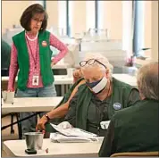  ?? DAVID ZALUBOWSKI / AP ?? Election judges look over ballots in the Denver Elections Division headquarte­rs on Tuesday in Denver.