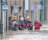  ?? ?? Emergency crews battle to safeguard families, pets and businesses after Storm Frank flooded the village of Ballater in 2015