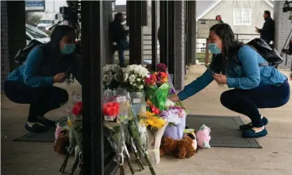  ?? Photograph: Elijah Nouvelage/Getty Images ?? A mourner lays flowers at the scene of one of the shootings in Atlanta.