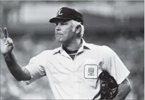  ?? AP PHOTO BY BRIAN HORTON ?? In this 1980, file photo, plate umpire Doug Harvey gestures before play resumes in the fourth inning of a baseball game between the Astros and Phillies in Houston. Harvey, one of 10 umpires enshrined in the baseball Hall of Fame, died Saturday