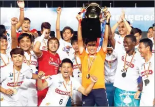  ?? SRENG MENG SRUN ?? Boeung Ket head coach Keo Kosal lifts the Metfone C-League trophy as his players celebrate winning the title at the end of last season.