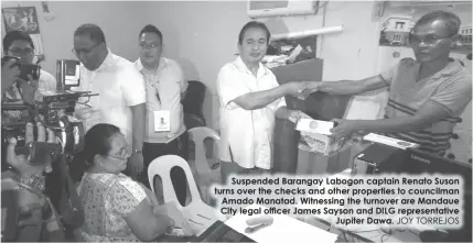  ?? JOY TORREJOS ?? Suspended Barangay Labogon captain Renato Suson turns over the checks and other properties to councilman Amado Manatad. Witnessing the turnover are Mandaue City legal officer James Sayson and DILG representa­tive
Jupiter Dawa.