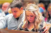  ??  ?? Brooklynn Sanders, daughter of bombing victim Sonja Lynn Sanders, and her boyfriend, Jacob Jones, bow their heads for 168 seconds of silence Tuesday during the 21st anniversar­y remembranc­e ceremony.