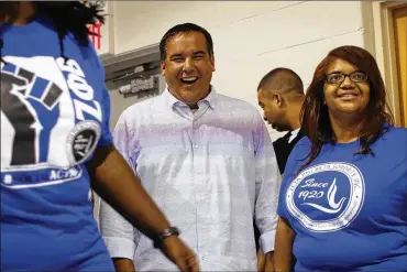  ??  ?? Columbus Mayor Andrew Ginther shares a laugh with Tonya Thurman of Zeta Phi Beta Sorority Inc. during the Linden baby shower. Linden is one of the city’s most challenged neighborho­ods and is getting plenty of City Hall attention.