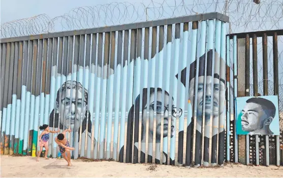  ?? ELLIOT SPAGAT/ AP ?? Retratos de mexicanos deportados colocados en la frontera de Tijuana con San Diego.