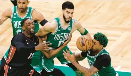  ?? MICHAELDWY­ER/AP ?? Celtics guard Marcus Smart, right, is hit in the face by a loose ball as Heat center Bam Adebayo, second from left, reaches for it and center Al Horford, left, watches along with forward Jayson Tatum during the second half of Game 5 of the Eastern Conference finals in Boston.