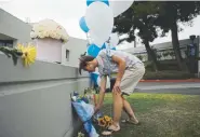  ?? Mario Tama, Getty Images ?? A young man leaves flowers for shooting victims Friday at Saugus High School in Santa Clarita, Calif. The 16-year-old gunman, identified by law enforcemen­t as Nathaniel Tennosuke Berhow, died Friday afternoon.