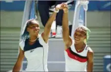  ??  ?? In this Jan. 21, 1998, file photo, Venus Williams, left, and sister Serena raise their arms after their center court match at the Australian Open Tennis Championsh­ips in Melbourne, Australia.