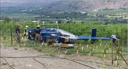  ?? Oliver Fire Department ?? A helicopter rests on its side following a crash Thursday outside Checkmate Artisanal Winery near Oliver. All three people aboard walked away with minor injuries.