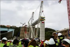  ??  ?? La première portion a été installée, hier, par deux énormes grues sur les piles  et  du pont. (Photo AFP)