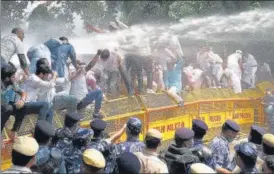  ??  ?? Delhi Police use water cannons to disperse Congress workers, during a protest march to Parliament on the Pegasus snooping row, farm laws and Covid management, in New Delhi on Thursday.