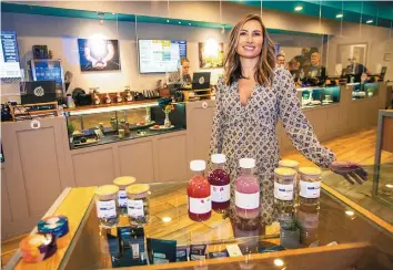  ?? ADOLPHE PIERRE-LOUIS/JOURNAL ?? Rachael Speegle, CEO of The Verdes Foundation, poses with edibles sold at her company’s dispensary in Albuquerqu­e.