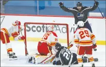  ?? CP PHOTO JOHN WOODS ?? Winnipeg Jets’ Adam Lowry celebrates Mason Appleton’s goal on Calgary Flames goaltender Jacob Markstrom during NHL action in Winnipeg Thursday.