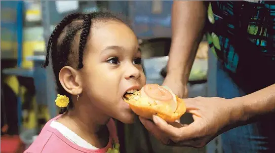  ?? Photog raphs by Kirk Mckoy
Los Angeles Times ?? YOUNG ELLA DAWSON samples a garnache at Ella’s Belizean Restaurant, which is named after her. The tiny eatery does mostly takeout for customers.