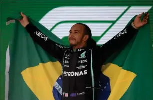  ?? (AFP/Getty) ?? The seven-time champion lifts the Brazilian flag after his triumph at Inter lagos last year