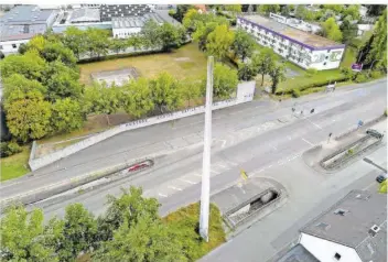  ??  ?? Die Gedenkstät­te Neue Bremm. Im Vordergrun­d das 30 Meter hohe Mahnmal. Die Mauer auf der anderen Straßensei­te trennt es von der Stätte. Kaum jemand weiß, was dieser „Mast“bedeutet. Manche halten ihn für einen Schornstei­n.