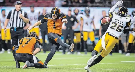  ?? DARRYL DYCK THE CANADIAN PRESS ?? B.C. Lions’ Ty Long (1) kicks the game-winning field goal as Hamilton Tiger-Cats’ Jumal Rolle defends during the second overtime.