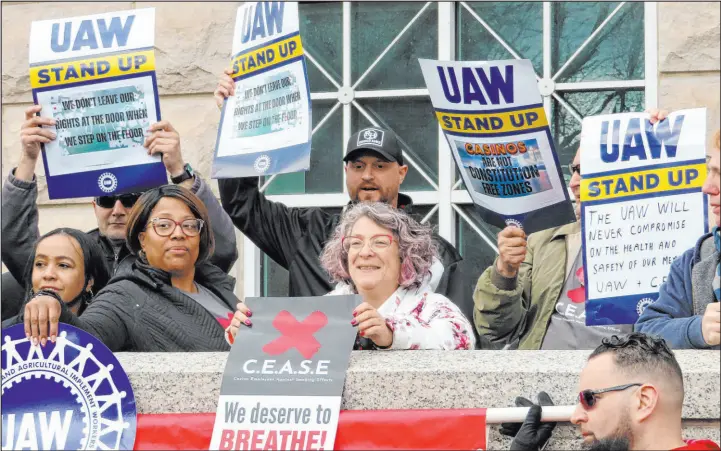  ?? Wayne Parry The Associated Press ?? Atlantic City casino workers hold signs during a rally in Trenton N.J., on Friday after filing a lawsuit challengin­g New Jersey’s clean indoor air law that exempts casino workers.