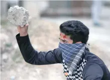  ?? — Reuters ?? A masked protester holds a rock during a protest in Srinagar. BJP president Amit Shah on Sunday said the central government is formulatin­g a ‘course of action’ to resolve the situation.