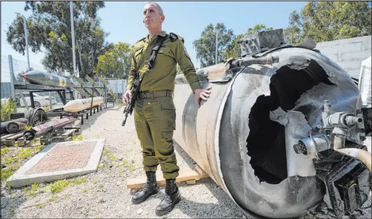  ?? Tsafrir Abayov The Associated Press ?? Israeli military spokesman Rear Adm. Daniel Hagari next to one of the Iranian ballistic missiles Israel intercepte­d last weekend.