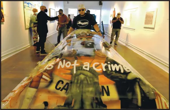  ?? RAY CHAVEZ — STAFF PHOTOGRAPH­ER ?? Oakland artist De Andre Drake stands with his work “My Skin Color Is Not a Crime” after it is delivered to Joyce Gordon Gallery, where it is on display through August.