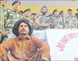  ?? SAMEER SEHGAL/HT ?? ■ Border Security Force officials with the nabbed Pakistani national and a carbine and ammunition seized from him at the Ranian border outpost in the Amritsar sector on Monday.