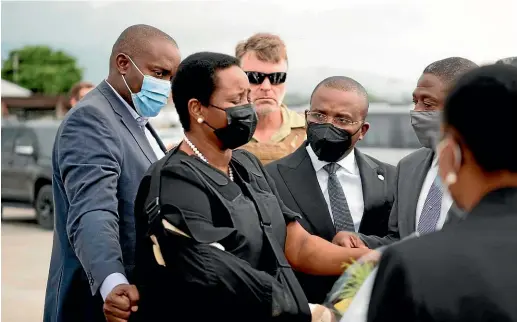  ?? AP ?? Haiti’s first lady, Martine Moise, wearing a bulletproo­f vest and with her right arm in a sling, arrives at the Toussaint Louverture Internatio­nal Airport, in Port-au-Prince, Haiti, where she was greeted by members of her late husband’s administra­tion.
