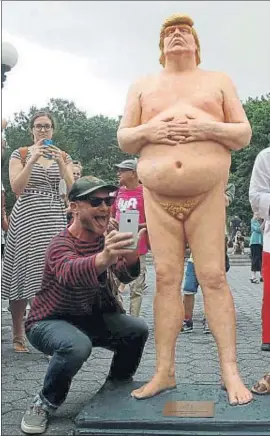  ?? BRENDAN MCDERMID / REUTERS ?? ‘Selfies’. Los paseantes de Union Square, en Nueva York, se toparon el viernes con esta estatua de Trump, luego retirada