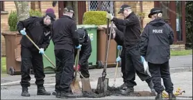  ??  ?? Crime scene: Police officers search for evidence outside the house