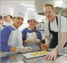  ??  ?? Young chefs Carla Donaldson and Lola Anderson prepare the entrés under the guidance of chef Toby Stuart.