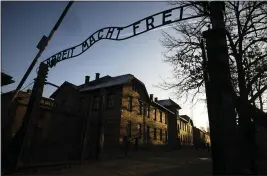  ?? MARKUS SCHREIBER ?? The sun lights the buildings behind the entrance of the former Nazi death camp of Auschwitz-Birkenau in Oswiecim, Poland.