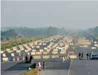  ?? AFP ?? Policemen stand at a roadblock on the motorway in Swabi in preparatio­n for an upcoming opposition protest. —