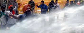  ?? — BIPLAB BANERJEE, G.N. JHA ?? Policemen use water cannons to disperse BJP workers (above) during a protest outside the CPM office in New Delhi on Monday against political violence in Kerala. CPI(M) general secretary Sitaram Yechury (right) with party leaders Prakash and Brinda...