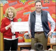  ?? (NWA Democrat-Gazette/Marc Hayot) ?? Randy Torres (right), a member of the Siloam Springs Public School Foundation, presents third-grade teacher Denise Wilmott with a check for $1,073 on Dec. 18. Wilmott’s project was External Monitors for Use with Small Group Literacy Instructio­n.