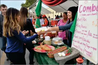  ??  ?? A vendor stays busy serving the public during last year’s Somerton Tamale Festival. The event that brings together tens of thousands of people resumes Saturday at 11 a.m. on Somerton’s Main Street.