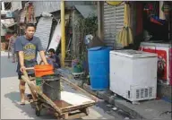  ??  ?? A man carts water to his home after filling up buckets at a neighbour’s house on lower ground during water shortages in Addition Hills, a slum in Metro Manila, in the first week of April this year.