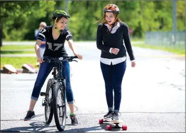  ?? NWA Democrat-Gazette/JASON IVESTER ?? Freshman Natasha Girenko (left) and senior Kelly Drake ride Tuesday during their physical education class at New Tech High School in Rogers. Under the direction of Deb Walter, the students are in their second week of a monthlong mountain bike unit...